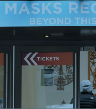 People walk into an entrance at the Space Needle under a sign that reads "Masks Required." Feb. 17. (Ted S. Warren/AP)