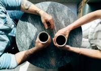 Birds-eye-view of two man drinking coffee at small table